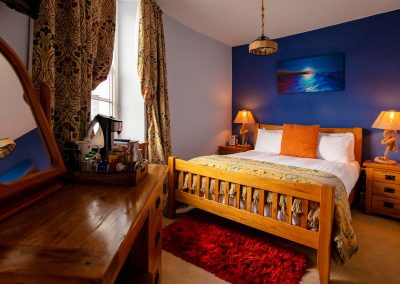 Warm and cozy super-king bedroom with an en-suite bathroom overlooking the River Dart.