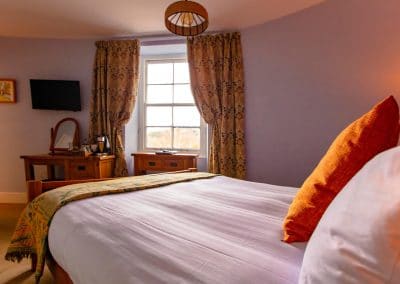 Warm and cozy super-king bedroom with an en-suite bathroom overlooking the River Dart.