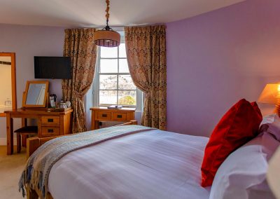 Warm and cozy super-king bedroom with a TV and en-suite bathroom that overlooks the stunning River Dart.