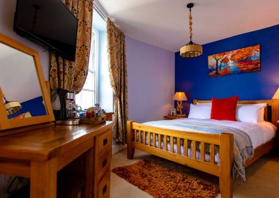 Warm and cozy super-king bedroom with an en-suite bathroom overlooking the River Dart.