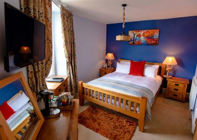 Warm and cozy super-king bedroom with an en-suite bathroom overlooking the River Dart.